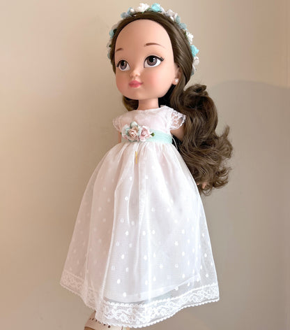 Muñeca de comunión personalizada como tú con vestido de manga corta, falda de tul de plumeti y cuerpo liso. Puedes personalizar el modelo de muñeca, el color del fajín, las flores y los zapatos. Sólo en My little twin.