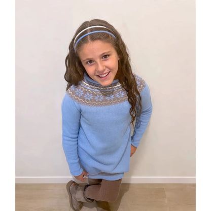 Niña sonriendo con vestido de punto celeste suiza jacquard nórdico - frontal