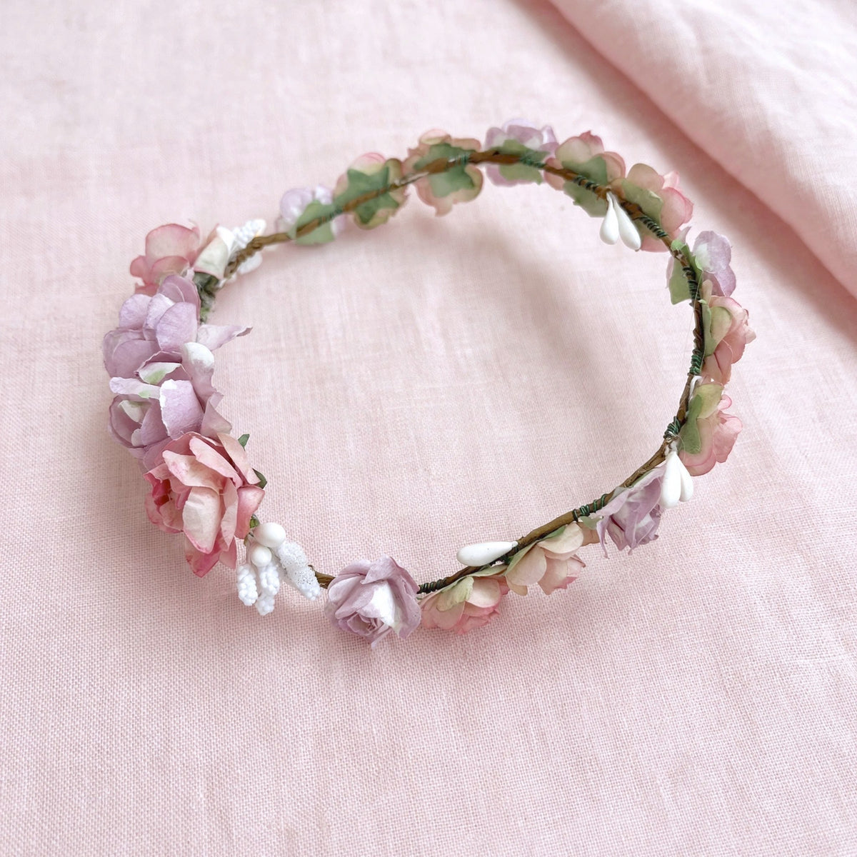 Coronita de flores Amelie para muñecas de comunión My little twin en tonos rosas y morados. Elige la más parecida a la niña y acompáñala con un bonito peinado. Se puede colocar con las flores grandes hacia delante o hacia atrás.