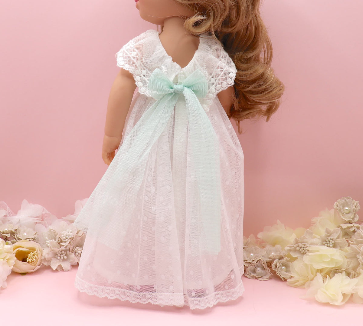 Espalda de muñeca de comunión personalizada como tú con vestido de tul de plumeti sin mangas y volante en escote bordado. Puedes personalizar el modelo de muñeca, el color del fajín, las flores y los zapatos. Sólo en My little twin