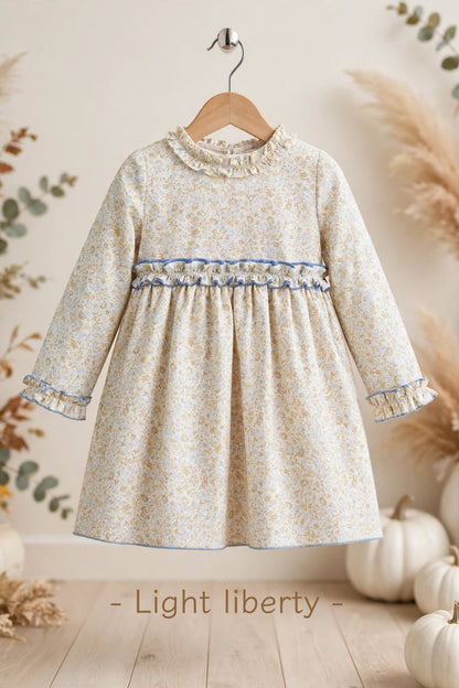 Vestido para niña con estampado floral en tonos celeste y camel, con precioso escote de doble volante y detalles de volante en puños y cintura. Disponible también a juego para su muñeca a juego en My little twin.