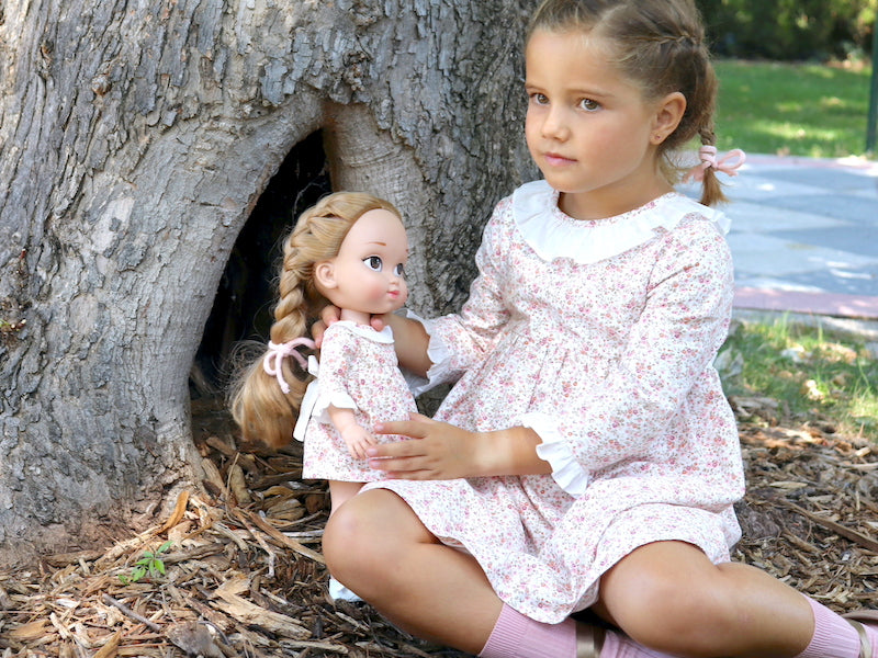 Pack de niña y muñeca iguales con el vestido de flores liberty en tonos rosa palo y detalles de volantes blancos de My little twin. Elige tu muñeca gemela, tu vestido preferido + el mismo vestido para tu muñeca, tu talla y un accesorio.