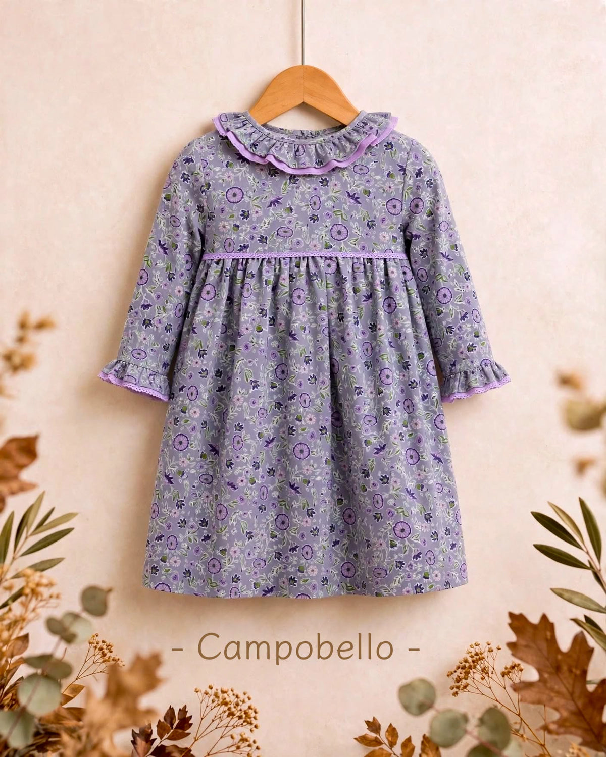 Vestido para niña con estampado floral en tonos malva y toque de verde, con precioso escote de doble volante y detalles de puntilla en malva. Disponible también a juego para su muñeca a juego en My little twin.