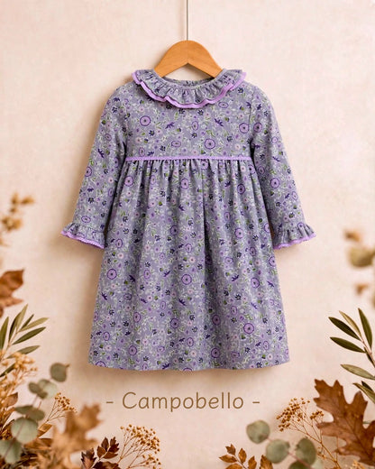 Vestido para niña con estampado floral en tonos malva y toque de verde, con precioso escote de doble volante y detalles de puntilla en malva. Disponible también a juego para su muñeca a juego en My little twin.