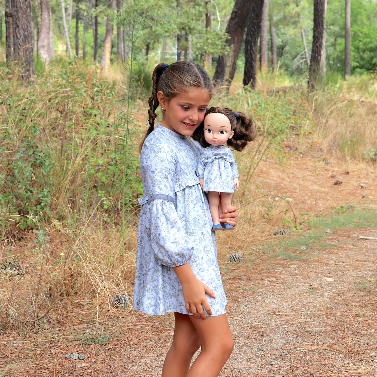 Niñas a juego con sus muñecas, niña y muñeca vestidas igual con vestido flores y cintas de terciopelo gris. Elige tu muñeca gemela, tu vestido preferido, tu talla y un accesorio en My little twin